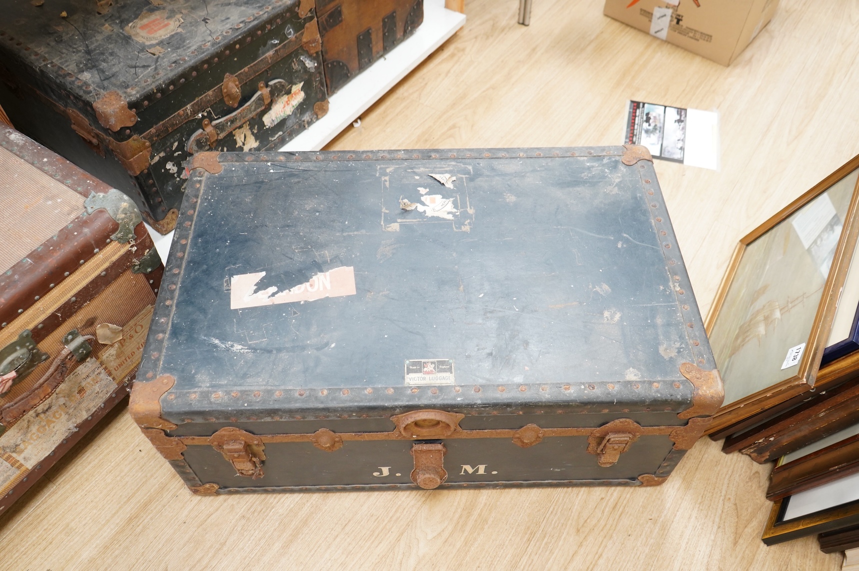 A collection of vintage luggage comprising four early 20th century bound travelling trunks and three kit bags